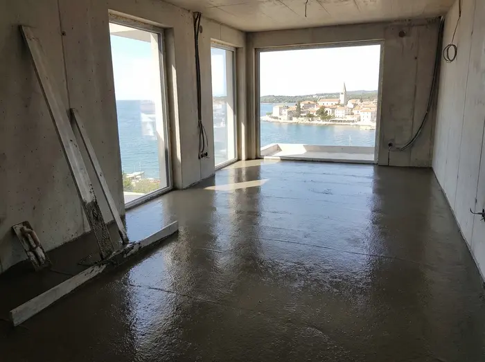 Svježe izliveni cementni estrih debljine 5 cm u novogradnji prepun slobodne vode koja mora ispariti.