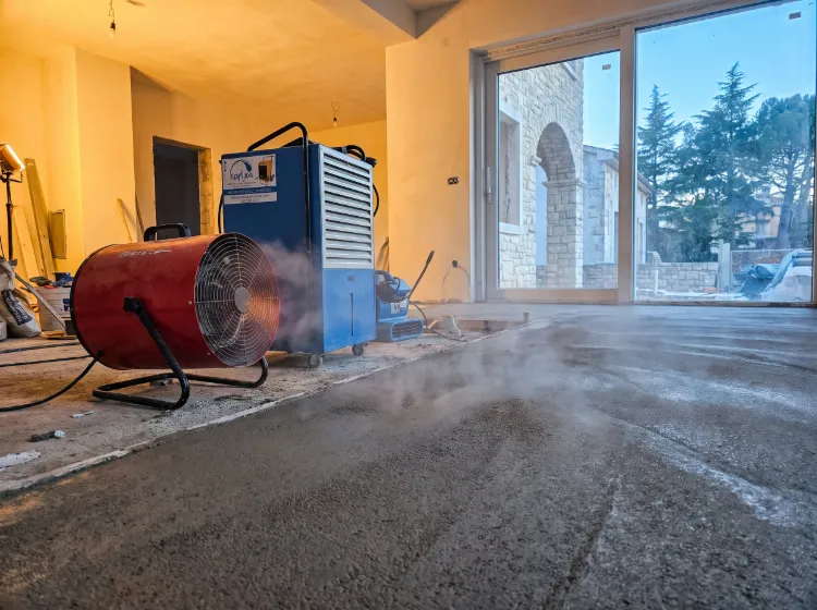Električni kalorifer i plavi isušivač vlage rade zajedno u prostoriji