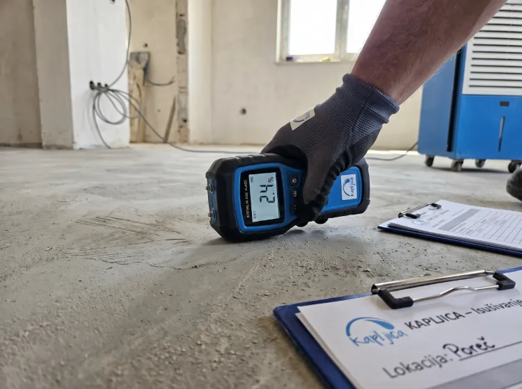 Profesionalni digitalni mjerač vlage na glatkom sivom betonskom estrihu - Isušivanje vlage